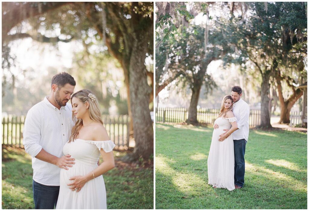 First time parents pose in the lush green grass with mossy oaks behind them for their maternity session in Jungle Gardens New Iberia Louisiana