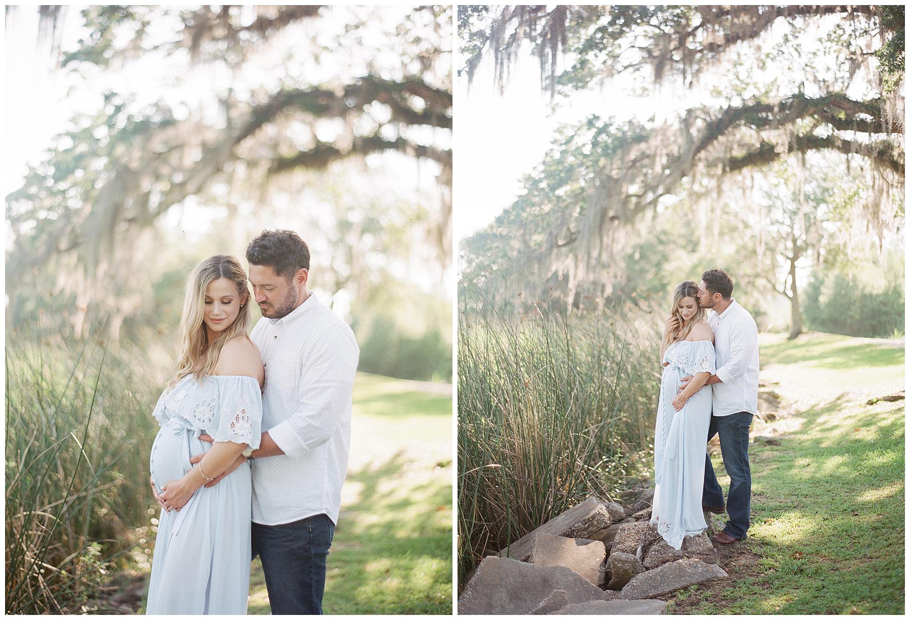In the heart of cajun country a couple poses for maternity portraits next to Bayou Teche. The background is of mossy oak trees