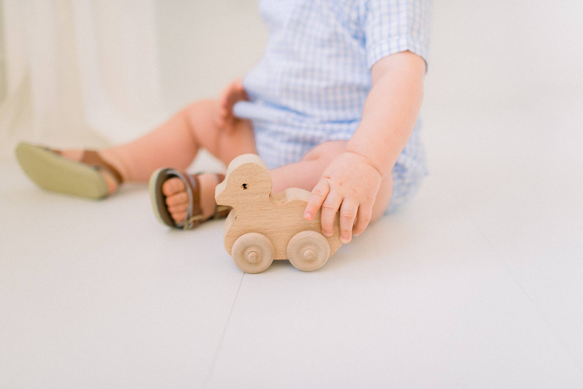 toddler playing with antique toy in photographers studio