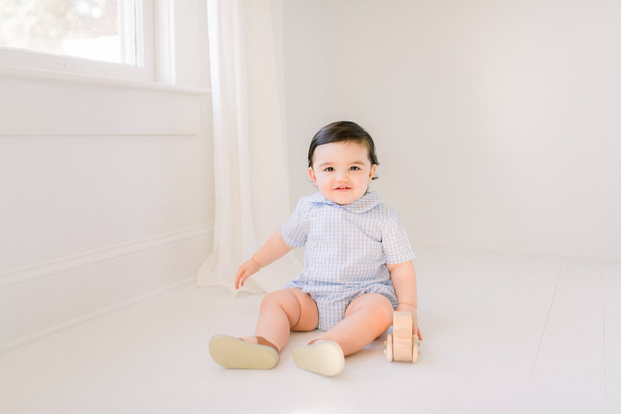 happy baby playing with toy in lafayette photographers studio