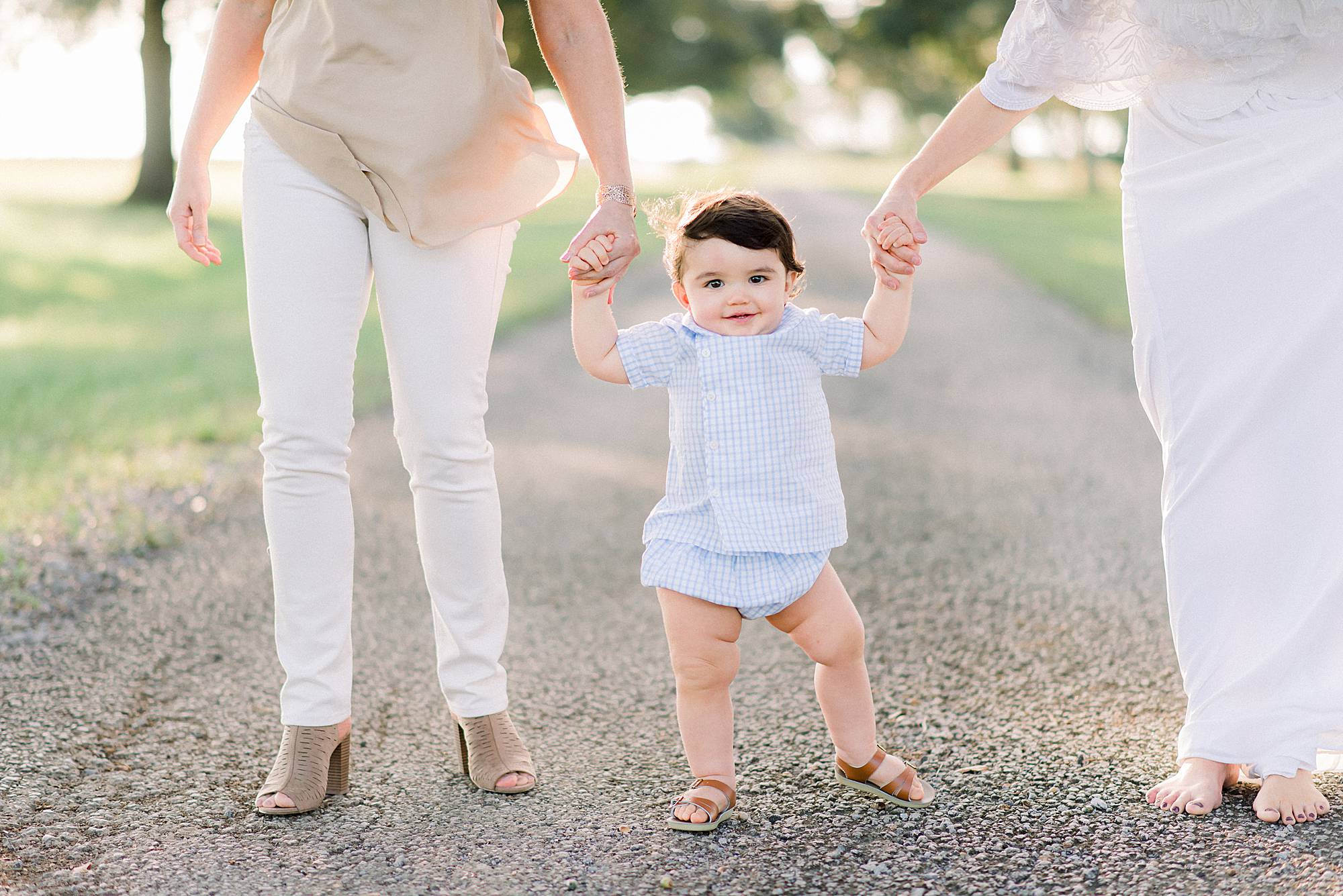 baby learning to walk holding handa