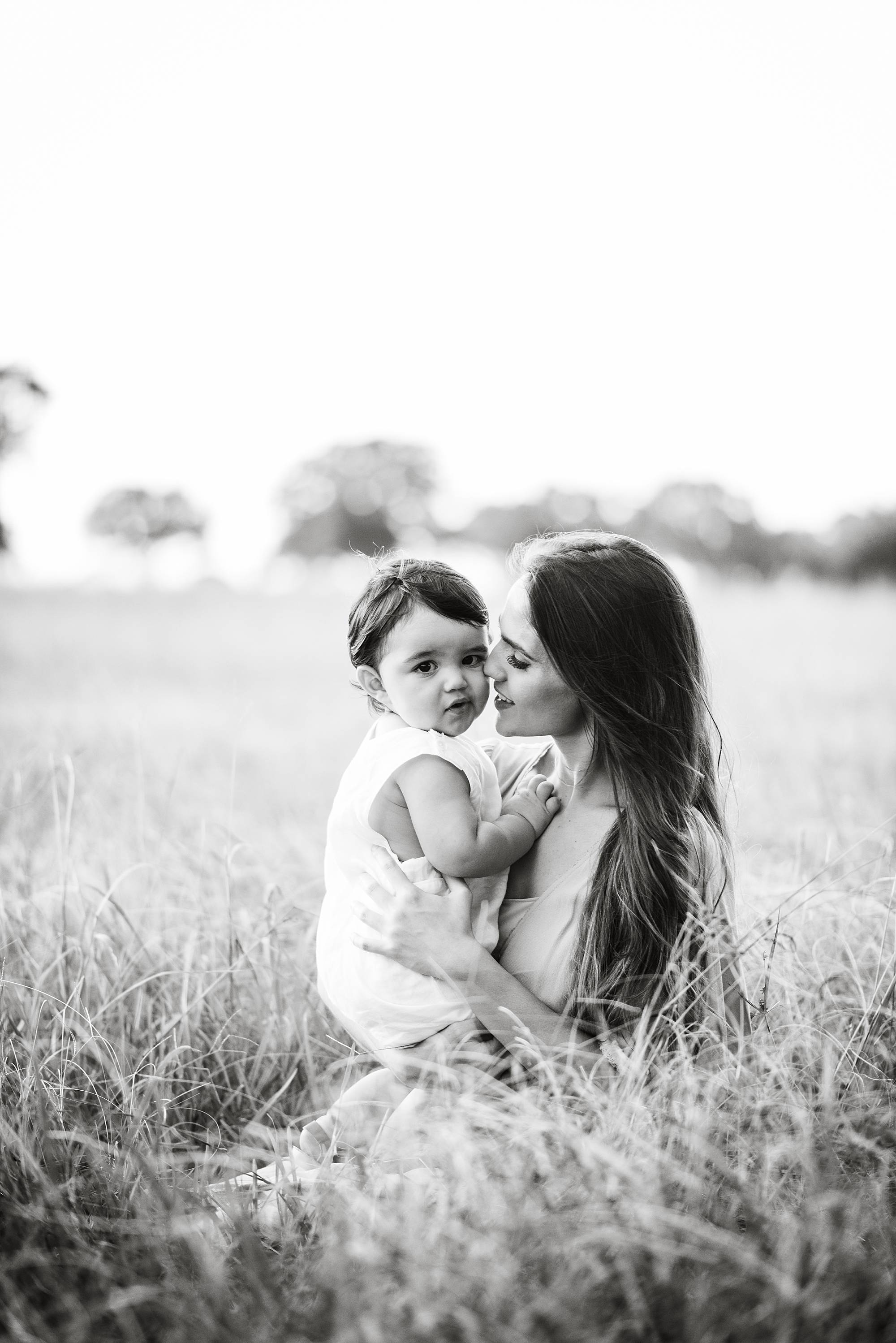 black and white portrait of mom holding baby in field