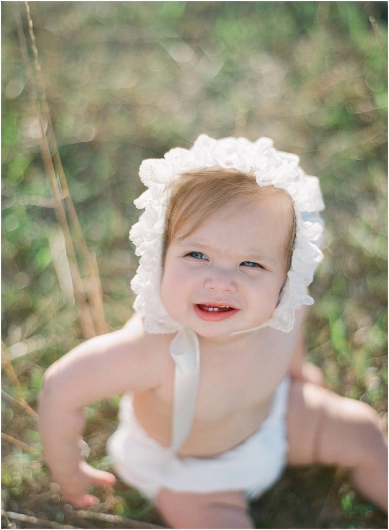 baby girl in bonnet and diaper cover photographed medium format film