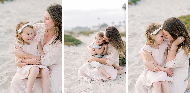 mom hugs her little girls on the beach while taking a photography session in San Diego