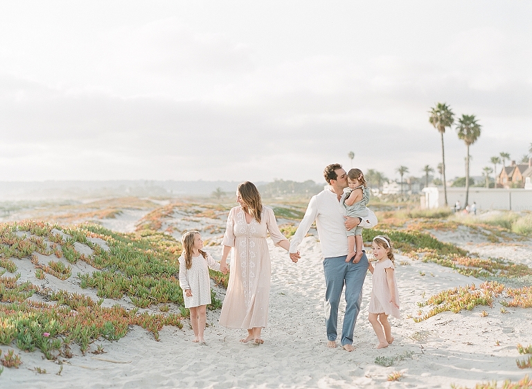 photography family session on Coronado Beach in San Diego California as they walk holding hands on the beach