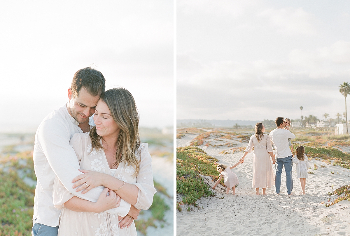 couple embraces each other and hugs and the kids hold hands and play in the sand at the beach