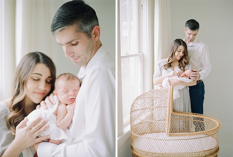 Newborn Photography studio taking portraits of mom dad and baby in an antique wicker bassinet in an all white natural light studio