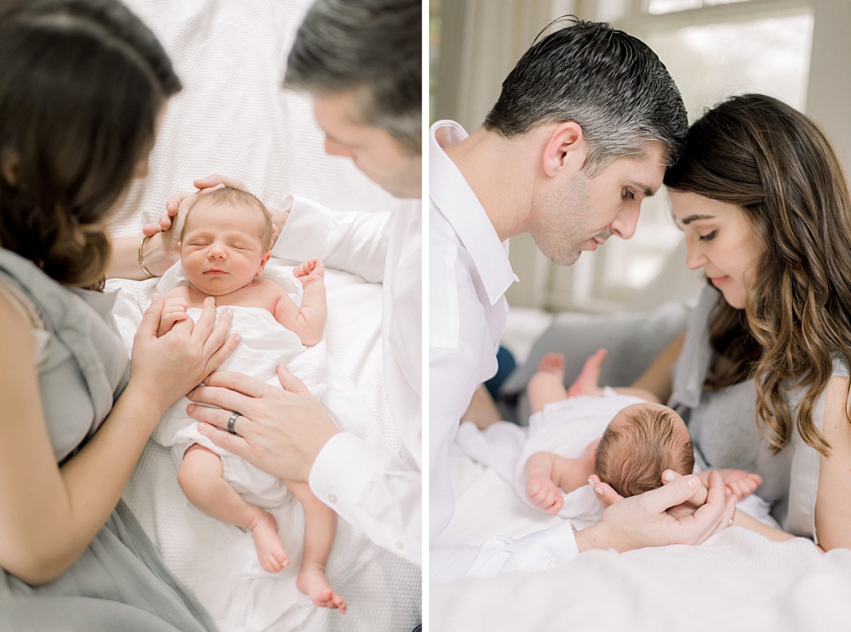 newborn baby session in all white natural light studio parents post with baby on bed