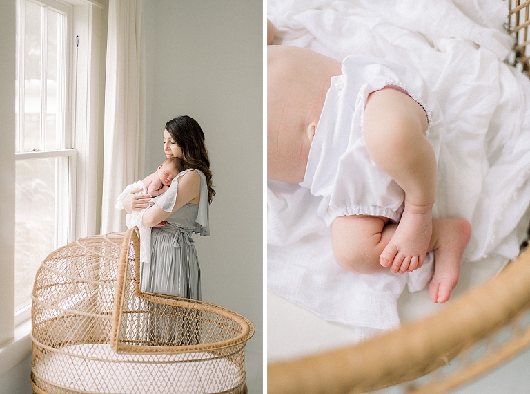 Mother holding newborn baby in front of antique wicker bassinet 