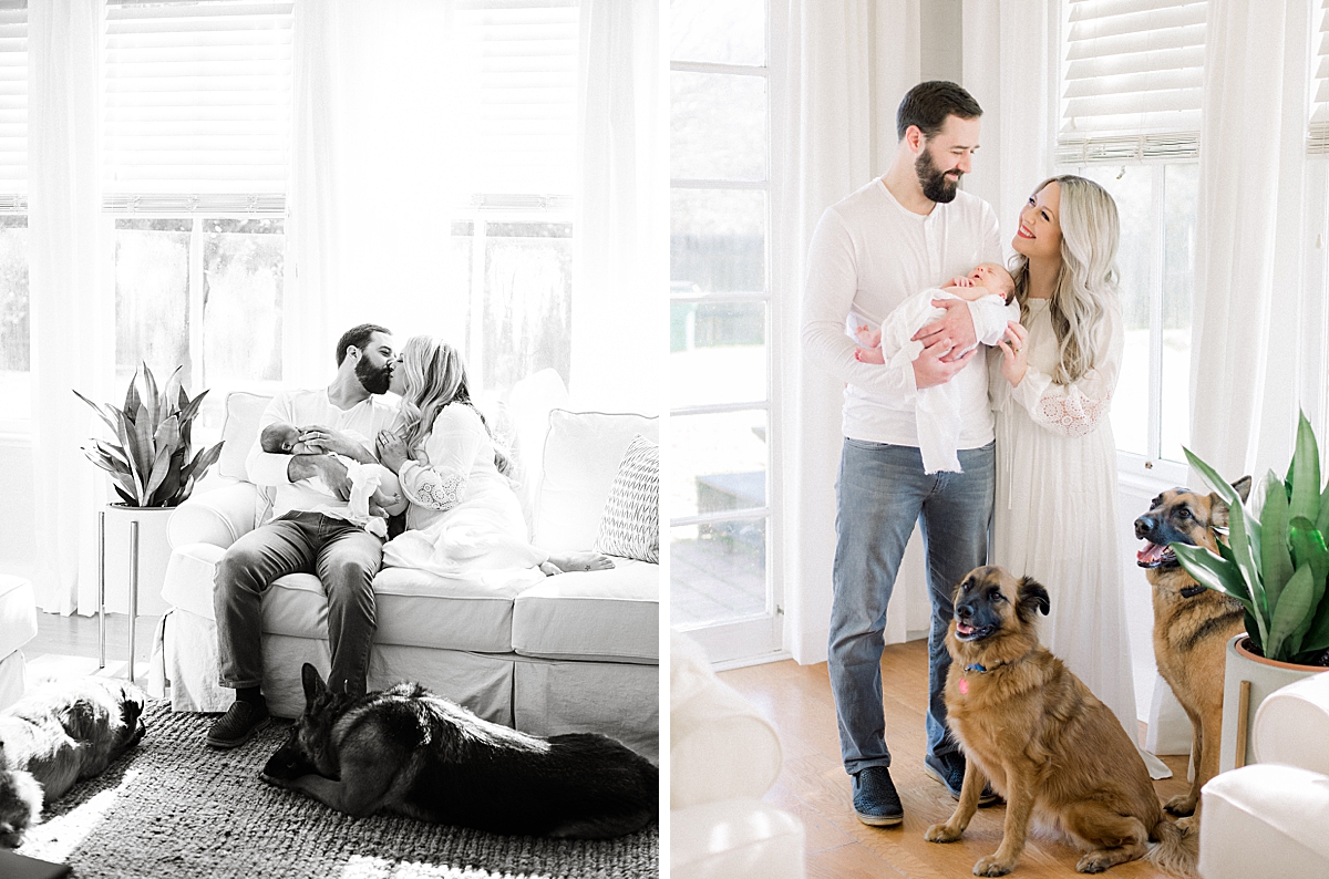 New parents share a kiss at home as they hold their newborn in their arms 