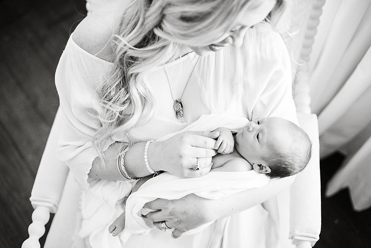 black and white portrait of a mother peering down at newborn baby boy after years of infertility 