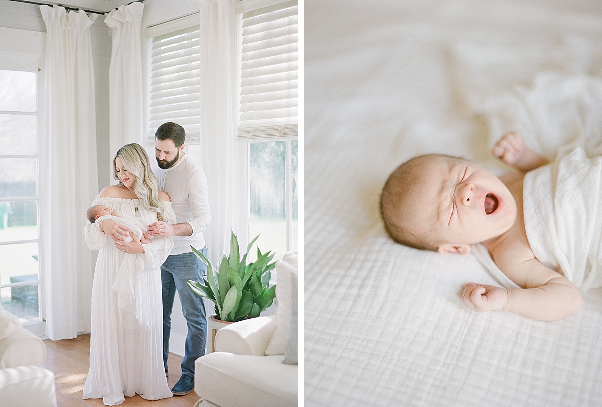 parents holding newborn baby boy and he yawns 